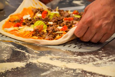 Pizzaiolo che prepara una pizza